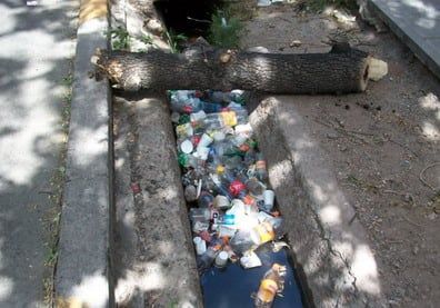Foto basura en la acequia capital