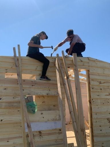 Martina construyendo junto a a sus compañeros de TECHO