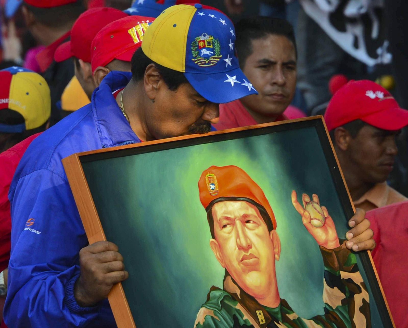 Pintura de Hugo Chávez sostenida por un militante del PSUV. Archivo MDZ