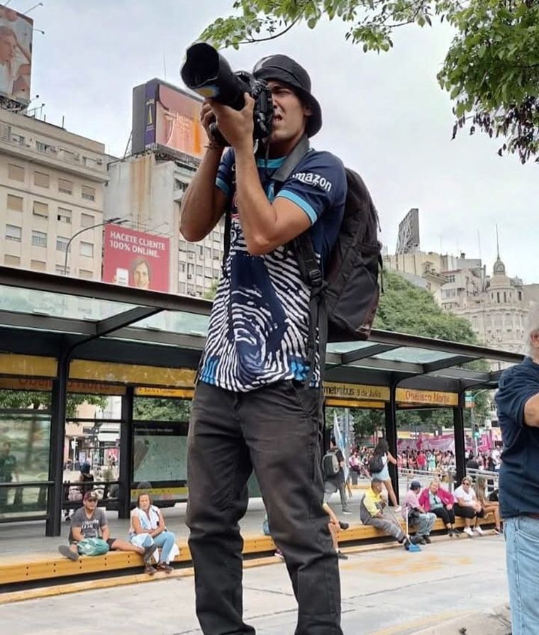 Pablo Grillo con su cámara de fotos y una camiseta del Napoli alusiva a Diego Maradona Foto: X