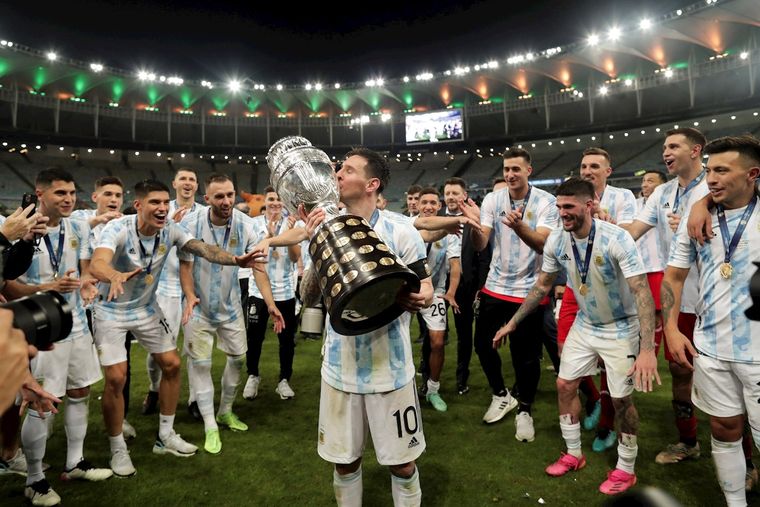 Lionel Messi besa la Copa América frente a la atenta mirada de sus compañeros. Foto: EFE