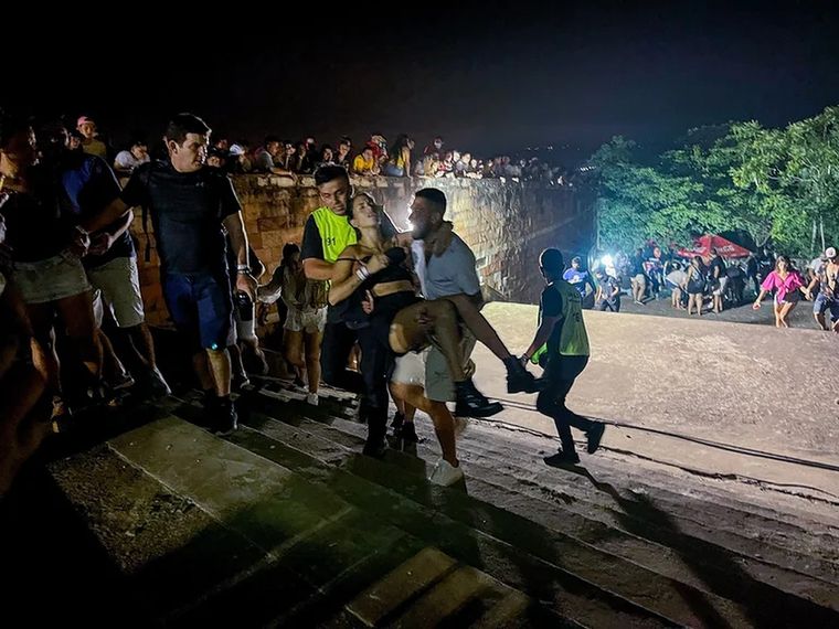 Personas cargando a una de las víctimas del tiroteo en Paraguay