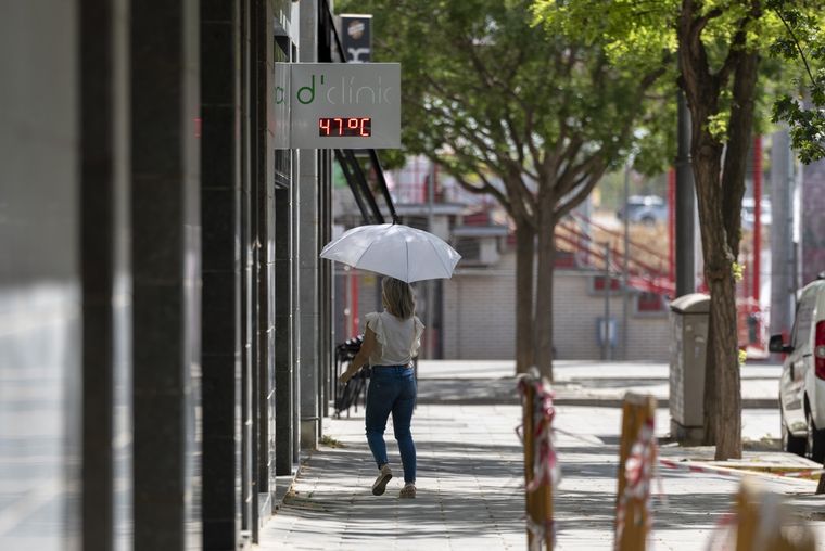 Una mujer camina por una calle de Lleida, bajo un termómetro que indica los 47ºC este miércoles, tercer día de ola de calor en Cataluña. Foto: EFE