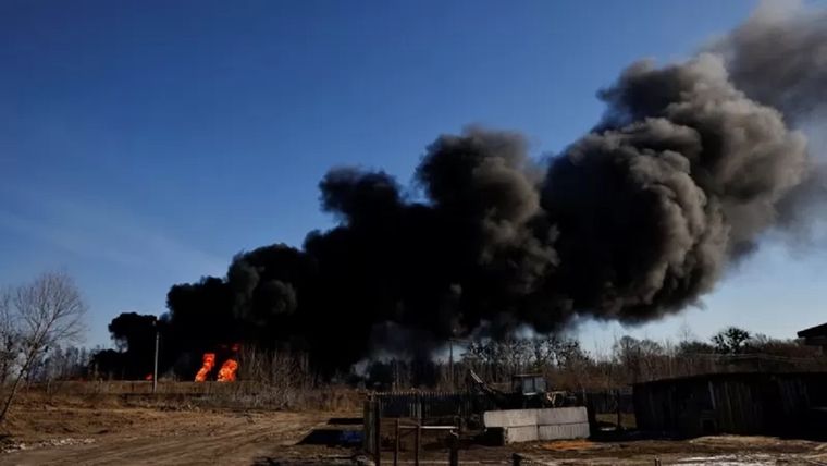 Una columna de humo se eleva desde tanques de combustible en llamas que, según los locales, fueron alcanzados por cinco cohetes en la base aérea de Vasylkiv, en las afueras de Kiev este 12 de marzo. Foto: Reuters