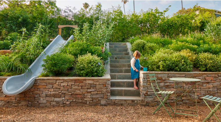 La clave para transformar este patio en un patio para niños ha sido aprovechar bien el espacio del desnivel para convertirlo en un jardín con senderos y además, un juego. Foto: sunset.com