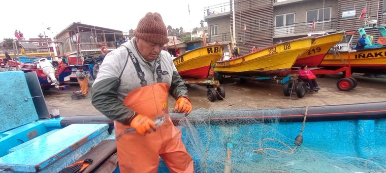 Guillermo selecciona los pescados y ordena la red, luego de estar varias horas en Pacífico adentro. Foto: Pablo Icardi