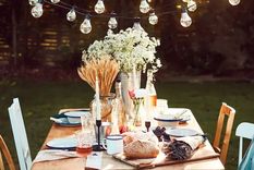 Para colgar guirnaldas de luces sobre un comedor al aire libre hay que utilizar postes y ganchos de madera para poder colocarlas con precisión sobre la mesa. Foto: Lights4Fun