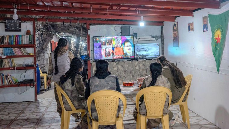 Las combatientes del PJAK siguen los acontecimientos fuera de su red de túneles viendo canales de noticias.
