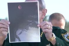 El sheriff del condado de Palm Beach, Ric Bradshaw, muestra una fotografía de la escopeta del sospechoso, con un bote de gasolina rojo visible en el fondo.