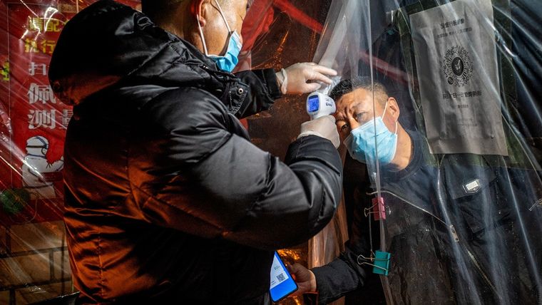 Miden la temperatura corporal a un residente antes de ingresar a una comunidad en Mudanjiang, China, 20 de abril de 2020,