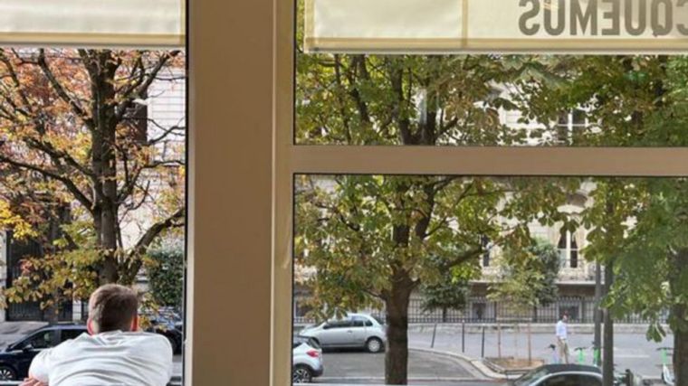 Jacquemus posando en la ventana de su local