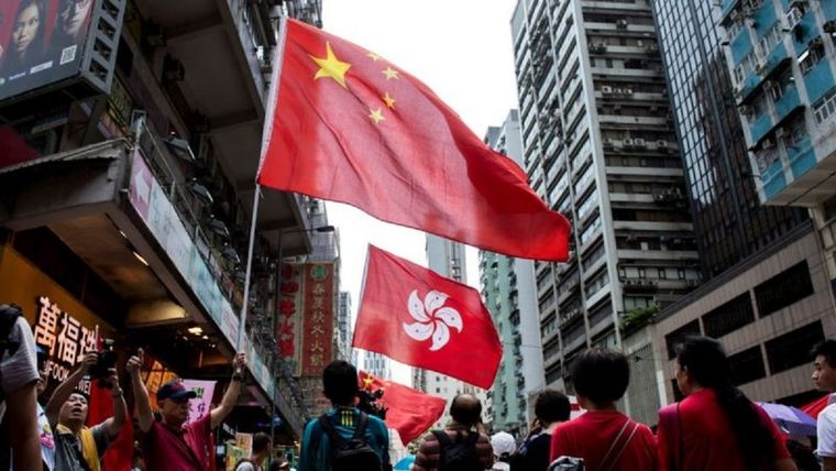 Manifestantes pro-China ondean las banderas de China y de Hong Kong durante un mitin progubernamental en esa isla. Foto: GETTY IMAGES