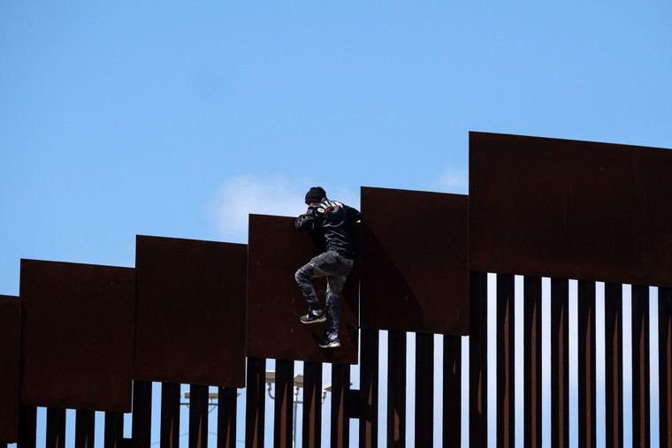 Un migrante intenta cruzar la frontera con EE.UU.
