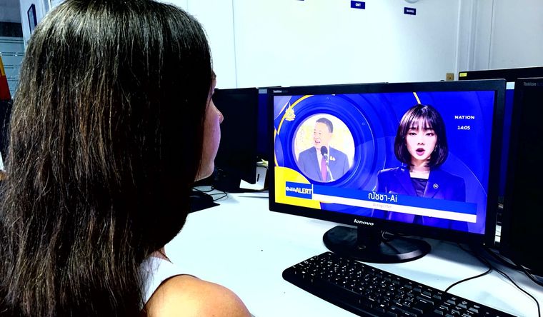 Una persona presencia el debut de Natcha, la primera informadora creada por inteligencia artificial (AI) en Tailandia. Foto: Efe.
