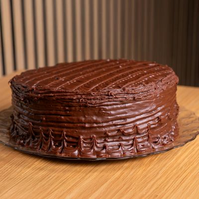 Cubrí la torta con la ganache de chocolate, dejá reposar unos minutos y serví.