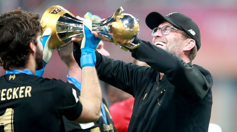 Klopp recibe la Copa de manos de su arquero, Alisson Becker. DPA Foto: DPA