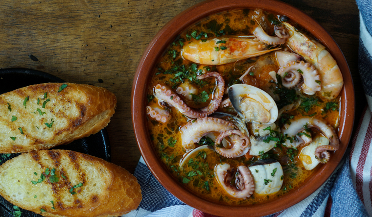 La receta de zarzuela de mariscos recibe su nombre por la variedad de ingredientes que combina, de forma similar a una obra musical con diferentes voces, lo que la convierte en una receta rica en matices y contrastes de sabores.