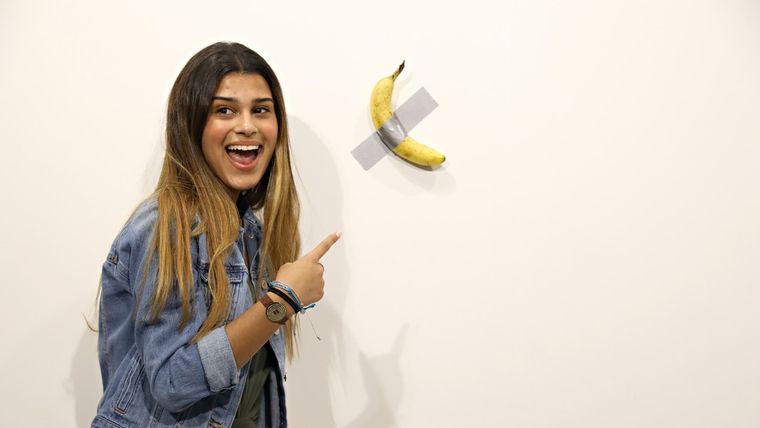 Visitantes posan con la obra de arte Comediante, que consiste en una banana adherida a la pared. Museo Perrotín, Miami, EE.UU. 6 de diciembre de 2019.