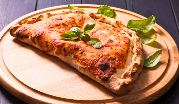 Calzone relleno de queso y jamón: la mejor forma de disfrutar de la pizza Foto: Shutterstock