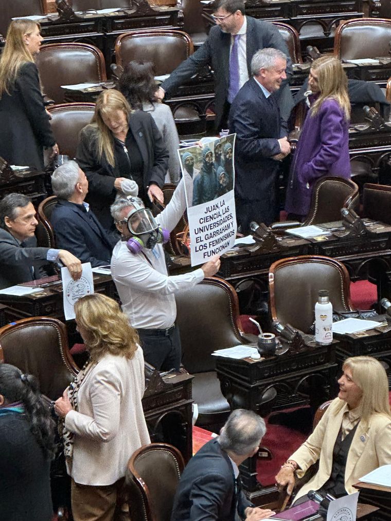 Esteban Paulón con una máscara y un cartel por el feminismo.