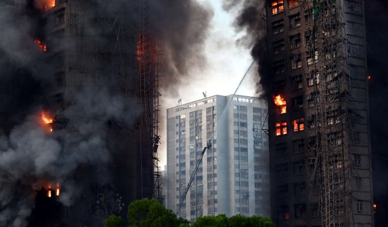 El incendio ha dejado personas que aún tratan de rescatar los bomberos de Hong Kong, China. Foto Dpa El incendio ha dejado personas que aún tratan de rescatar los bomberos de Hong Kong, China. Foto Dpa
