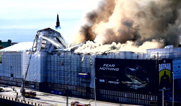 El edificio de la antigua bolsa de Copenhague, del siglo XVII, envuelto en llamas y humo. Foto: Efe.