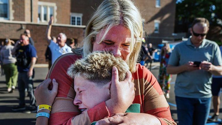 Una madre abraza a su hijo tras un tiroteo en la Iglesia de la escuela católica Anunciación, en Minneapolis, Minnesota.