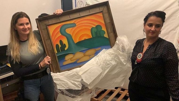 Las autoridades sostienen la pintura de la artista Tarsila do Amaral titulada Sol Poente después de que fuera incautada durante una operación policial en Río de Janeiro, Brasil. Foto: REUTERS