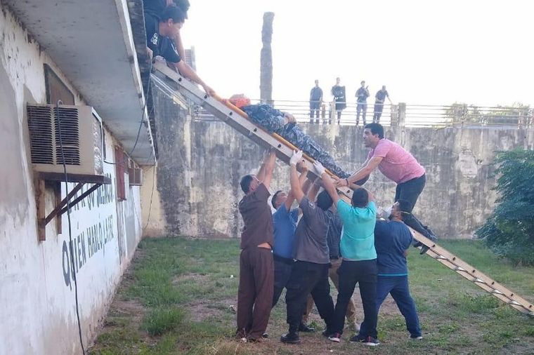Personas del penal de Coronda, en Santa Fe, asisten a un agente penitenciario herido durante los incidentes
