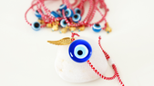 Muchas personas usan una pulsera roja con un ojo turco como amuleto. Muchas personas usan una pulsera roja con un ojo turco como amuleto.