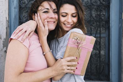 MDZol | abrazar-las-mujeres-con-un-regalo-cerca-de-la-puerta