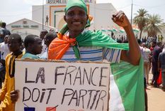 Un hombre sostiene una pancarta con la frase: Francia debe irse Foto: EFE