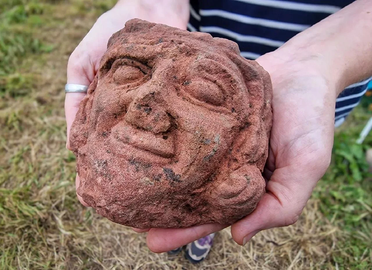 Cabeza tallada en piedra arenisca roja, hallada en las islas Orcadas durante las excavaciones en el sitio de Skaill. La escultura presenta una expresión serena y detalles faciales distintivos. Cabeza tallada en piedra arenisca roja, hallada en las islas Orcadas durante las excavaciones en el sitio de Skaill. La escultura presenta una expresión serena y detalles faciales distintivos.