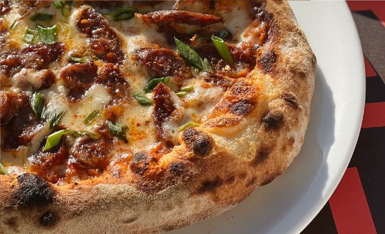 Esta pizza con cubierta de salchicha parrillera y verdeo es deliciosa y fácil de hacer. Con estilo italo americano y sello argentino. Foto: Instagram