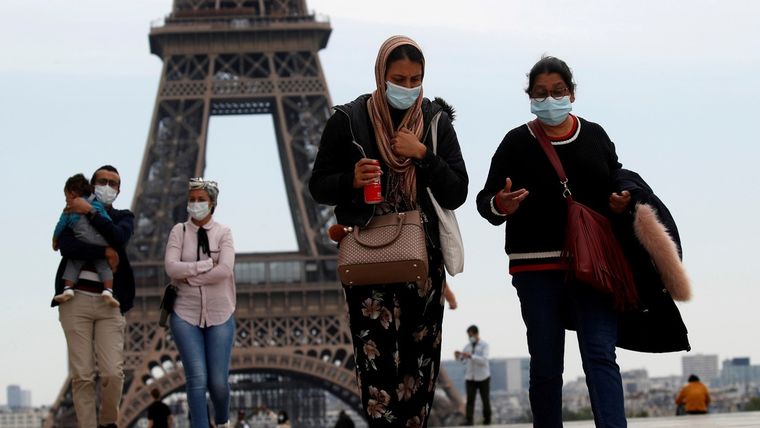 Personas con mascarilla caminan por la plaza Trocadero, cerca de la Torre Eiffel, en París (Francia), el 16 de mayo de 2020.