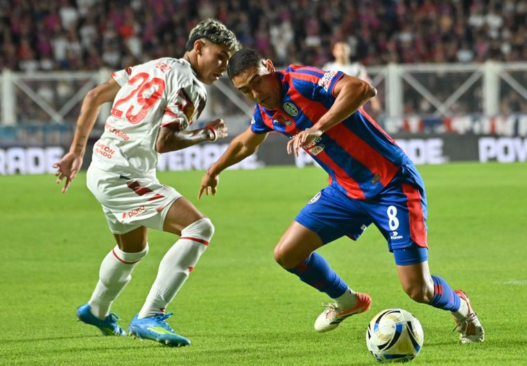 Manuel Insaurralde (8), mediocampista de San Lorenzo, deja en el camino a Fabricio Pérez (29), jugador de Estudiantes.
