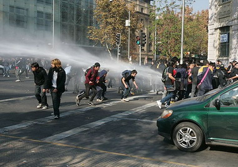 Momento en que los estudiantes eran dispersados por carros hidrantes.
