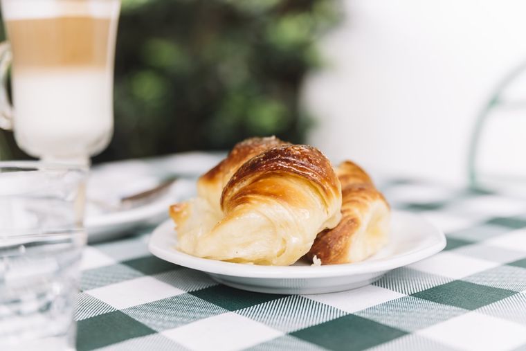 La promo 1 siempre consiste en una taza grande de café con leche, con dos medialunas, intercambiables por dos tortitas mendocinas. Foto: Freepick.