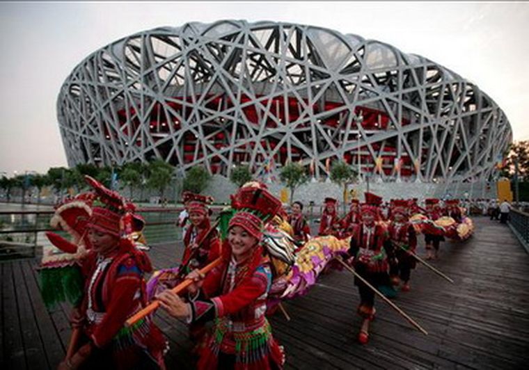 Un grupo de artistas se prepara en el exterior del Estadio Nacional, conocido como El Nido, antes de que dé comienzo un ensayo general. Foto: EFE
