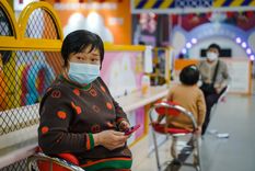 Una mujer con mascarilla usa un teléfono móvil en un centro comercial de Pekín. Foto: EFE/EPA/Wu Hao Una mujer con mascarilla usa un teléfono móvil en un centro comercial de Pekín. Foto: EFE/EPA/Wu Hao