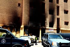 Un policía kuwaití se encuentra frente a un edificio residencial después de que se produjera un incendio. Foto: Efe.