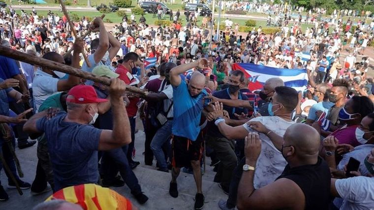Seguidores del gobierno golpean con palos a manifestantes del 11-J. Foto: REUTERS