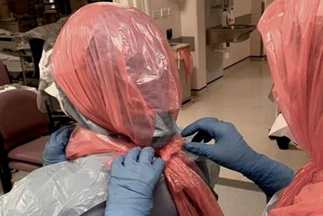 La doctora Roberts ayuda a sus colegas a ponerse bolsas de basura en la cabeza.