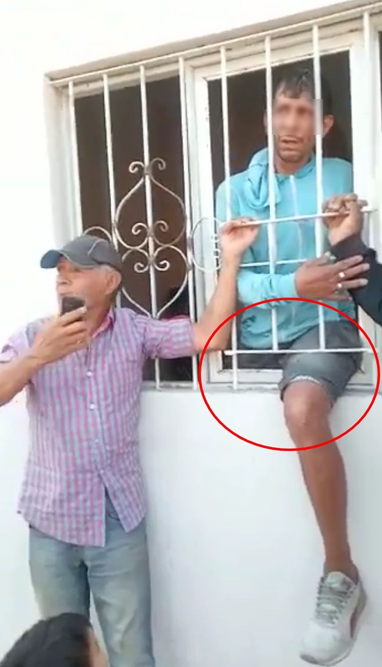 Preocupado El sospechoso parece bastante preocupado mientras los vecinos esperan a los efectivos policiales.