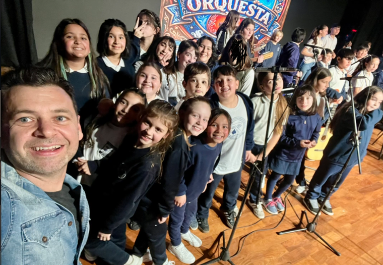 El profesor de música Pablo Andrés Parente junto a sus alumnos de 5° y 6° del colegio Santa Rosa de Viterbo y el coro de la escuela San Carlos, de la provincia de Santa Fe.