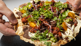 Esta receta de tlayudas es conocida como la “pizza oaxaqueña” por su tamaño y variedad de ingredientes, aunque conserva técnicas totalmente tradicionales.