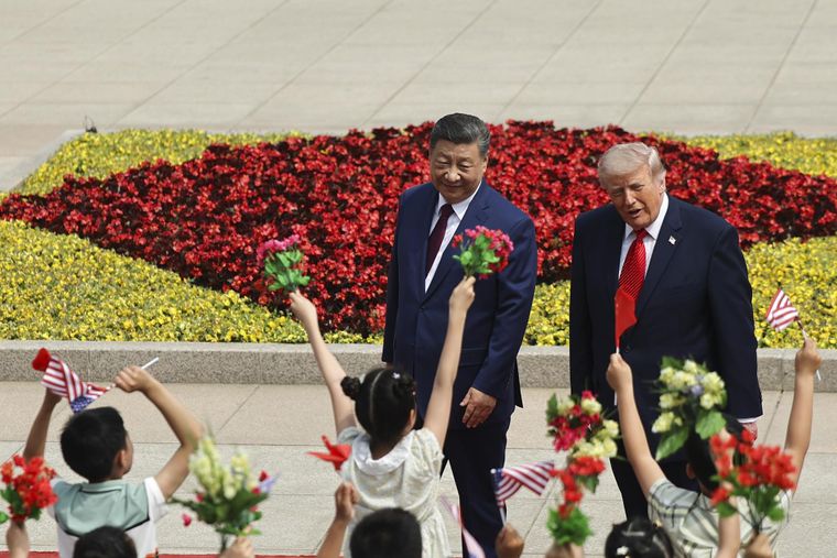 Donald Trump y Xi Jinping caminan juntos a la par.