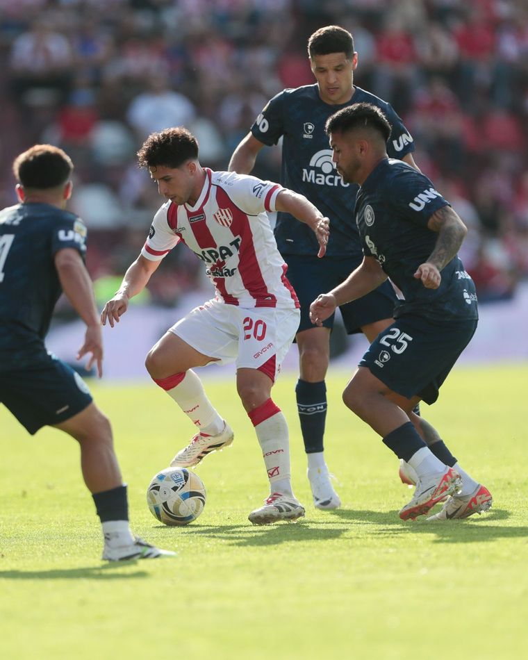 Julián Palacios, mediocampista de Unión, maneja el balón rodeado de tres jugadores azules: Gómez, Amarfil y Arce. Julián Palacios, mediocampista de Unión, maneja el balón rodeado de tres jugadores azules: Gómez, Amarfil y Arce.