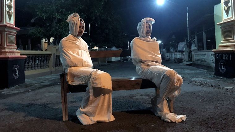 Voluntarios disfrazados de fantasmas en la aldea de Kepuh, Indonesia, 1 de abril de 2020.