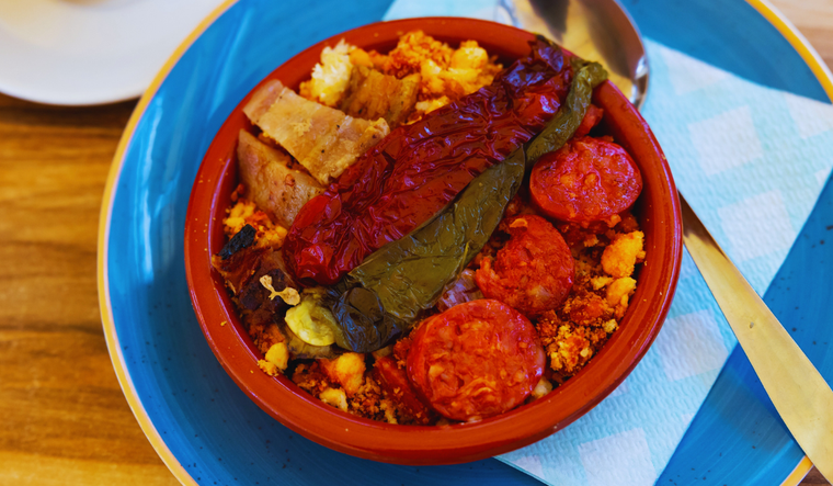 La receta de migas tiene orígenes pastoriles y se preparaba como una forma de aprovechar el pan duro en los largos días de trabajo en el campo.